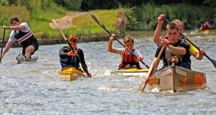 Fitness for Paddlesport. A group head out on the water in different craft.