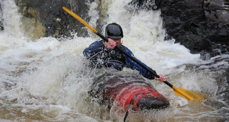 Optimising Fitness and Performance for Paddlesport (Part 2). A kayaker concentrates on the water ahead in rough water.