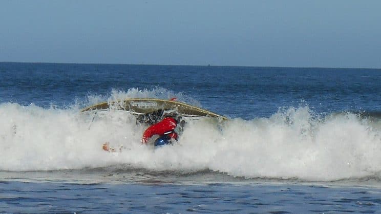 Surf Safety and Rescue. A surf kayaker being wiped out on a wave.