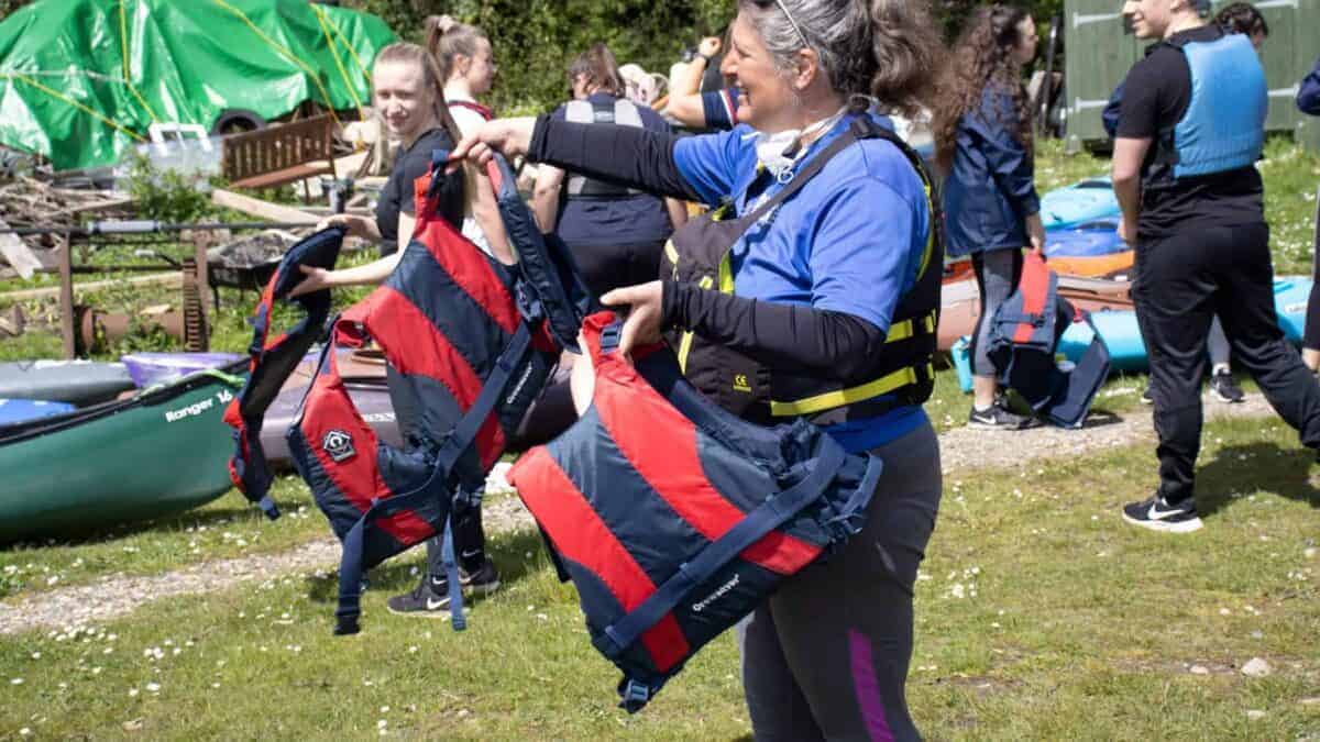 An organiser hands out life jackets
