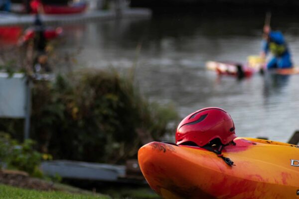 Helmet resting on a kayak. Equipment management and safety elearning