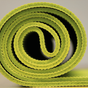 A rolled up lime green yoga mat