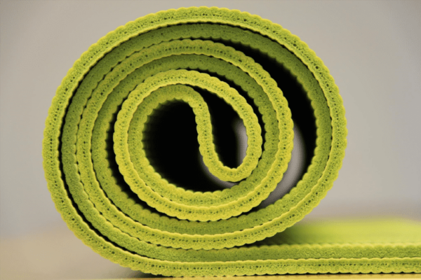 A rolled up lime green yoga mat
